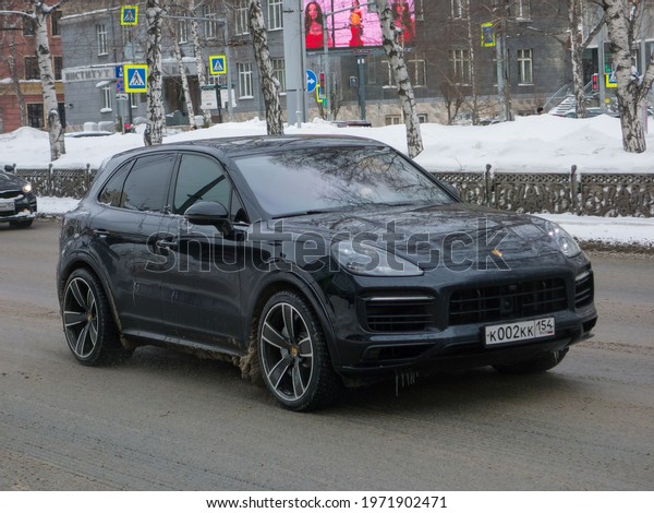 Novosibirsk, Russia - march 05 2021: private\
all-wheel drive black metallic color germany sport coupe SUV\
Porsche Cayenne S (PO536) luxury car awd 4wd 4x4 from Germany\
driving on winter snow\
street