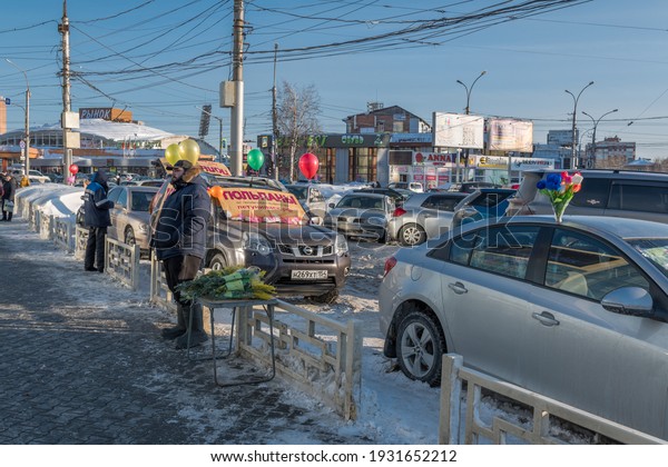 NOVOSIBIRSK, RUSSIA - March  08, 2021: Illegal trade\
in flowers from a car in front of a flower shop, on the eve of\
March 8 in Russia (March 8 in Russia is celebrated as International\
Women\'s Day)