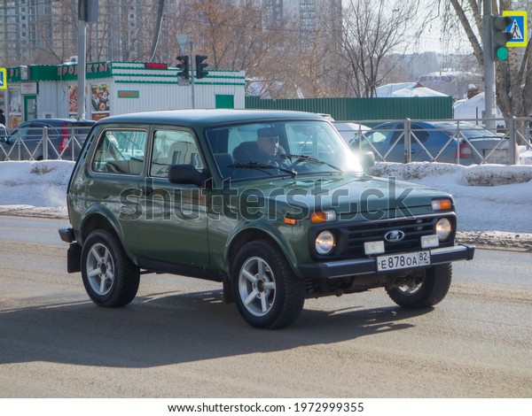 Novosibirsk, Russia - march 09 2020: army green metallic\
color russian awd drive old classic SUV crossover Lada 21214 Niva\
4x4 started to be released USSR Soviet Union driving on snow winter\
street 