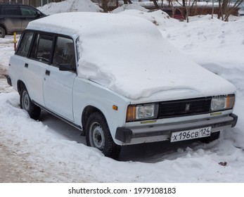 Novosibirsk, Russia - March 11 2021: White Metallic Color Russian Rwd Drive Old Classic Vintage Station Wagon VAZ Lada 2104 Zhiguli, Started To Be Released Soviet Union Parking On Snow Winter Street