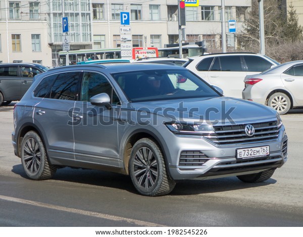 Novosibirsk, Russia - march 15 2021: private awd\
all-wheel drive silver gray steel metallic color germany sport\
coupe crossover new Volkswagen Toureg, luxury car SUV 4wd driving\
on city urban\
street