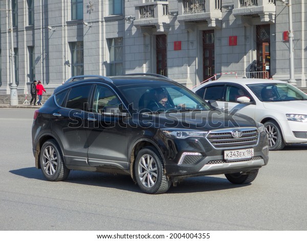 Novosibirsk, Russia - March 17 2021: private awd\
all-wheel drive black metallic color chinese family midsize SUV FAW\
Besturn X80 facelift, new car crossover made in China driving on\
urban broad street