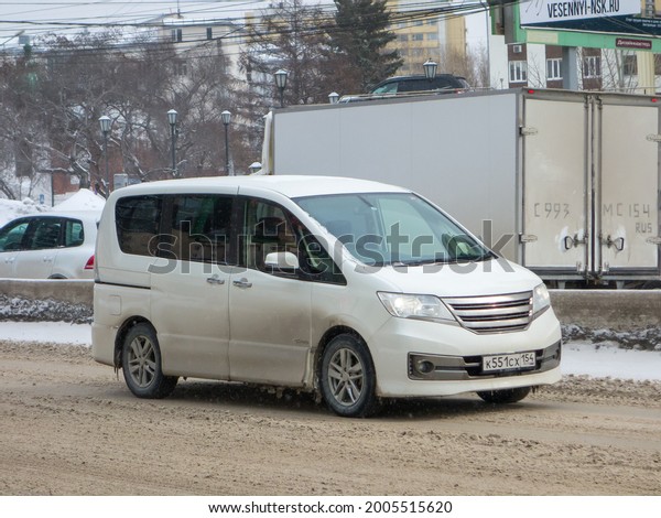 Novosibirsk, Russia - march 18 2021: private white\
japanese passenger minivan Autech Nissan Serena Rider C26, rare\
mini van bus car made in Japan on winter dirty snow urban street\
tuned and modified\
