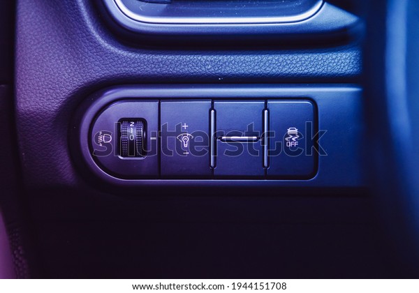 Novosibirsk, Russia – March 26  2021: Kia Ceed, \
Close-up on the headlight switch control buttons,  automatic adjust\
level dashboard. modern car interior: parts, buttons, knobs under\
pink neon light