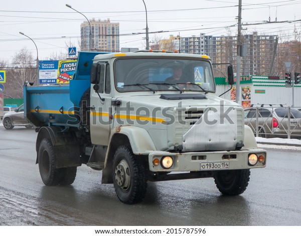 Novosibirsk, Russia - march 26 2021: private blue\
gray metallic color heavy frame small russian dump truck chassis\
ZIL MMZ 45085, old vintage classic car made in russia driving on\
urban spring\
street