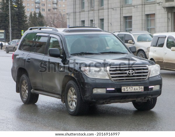 Novosibirsk, Russia - March 26 2021: private awd\
all-wheel drive black metallic color japanese big frame luxury SUV\
Toyota Land Cruiser 200, fullsize old car crossover driving on\
broad street\
road\
