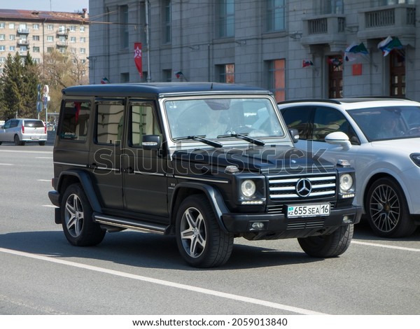 Novosibirsk, Russia, may 07 2021: private big 4wd\
awd all-wheel drive black metallic color germany SUV Mercedes-Benz\
G 55 AMG Styling 4МАТIС W463 old luxury car crossover driving on\
urban broad street