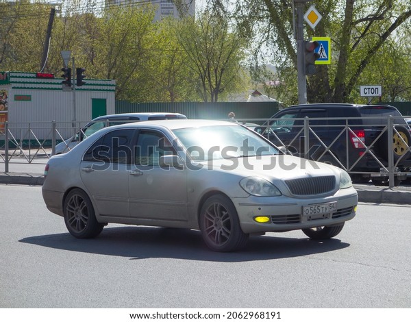 Novosibirsk, Russia - may 11 2021: private silver\
gray metallic color old japanese rear-wheel drive car Toyota\
Brevis, rare sport sedan made in Japan 00s 2000s drive on urban\
bright sunny broad\
street