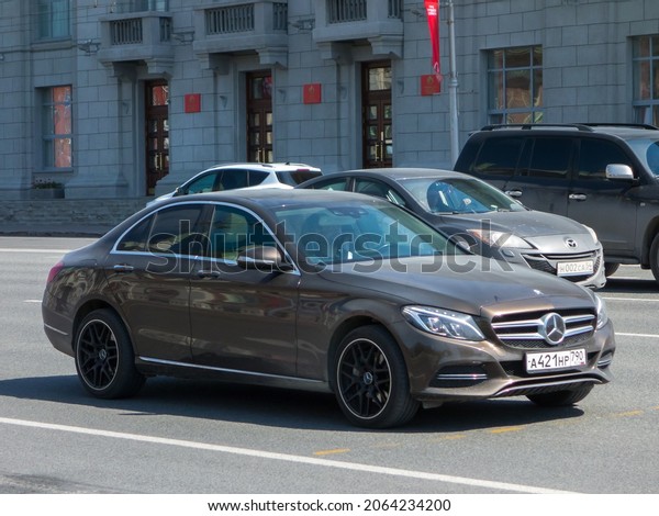 Novosibirsk, Russia - may 12 2021: private rwd\
brown metallic color germany sedan Mercedes-Benz C-klasse C250 W205\
AMG Styling black disks, luxury car made in Germany drive on city\
urban sunny street
