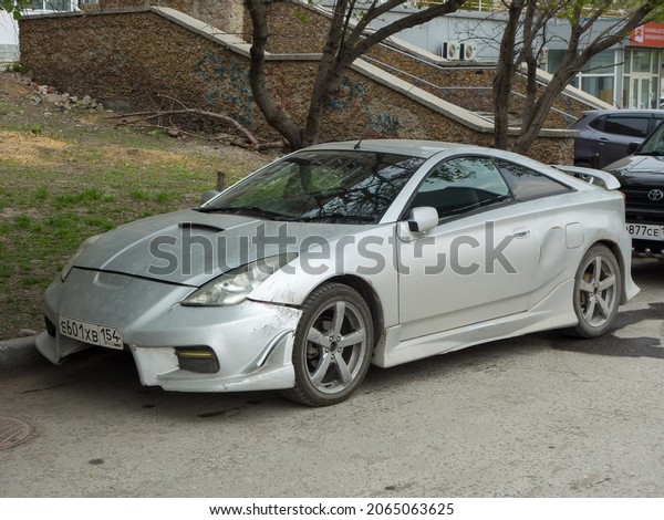 Novosibirsk, Russia, may 13 2021: private silver\
gray metallic old japanese fwd front wheel drive poor car Toyota\
Celica, old classic sport coupe 90s 2000s parking on dirty city\
urban street in\
yard