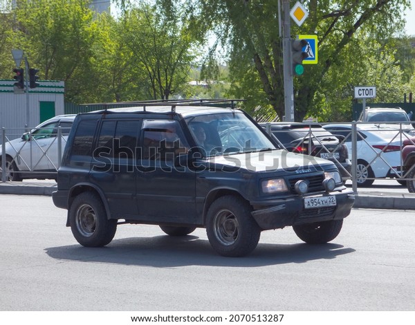 Novosibirsk, Russia, may 14 2021: private\
all-wheel drive gray black metallic color japanese frame SUV Suzuki\
Escudo Nomade 80s 90s, popular old retro car crossover drive on\
city urban sunny\
street