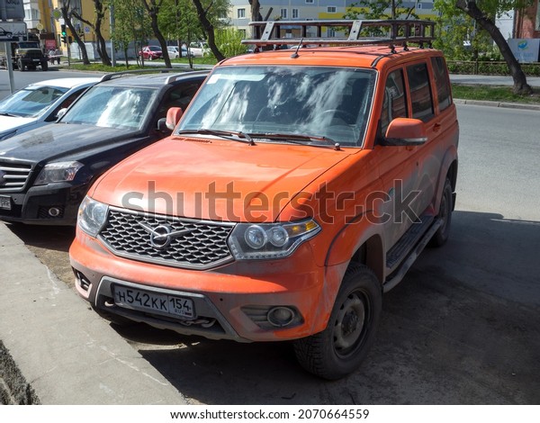 Novosibirsk, Russia, may 14 2021: private awd\
all-wheel drive orange metallic color russian new trophy frame\
crossover 4x4 4wd UAZ 3163 Patriot Expedition facelift car SUV\
parking on city urban\
street