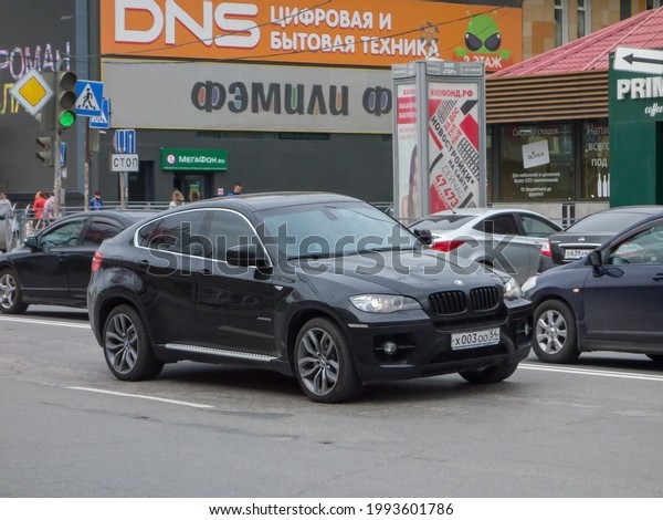 Novosibirsk, Russia - may 17 2021: private awd 4wd\
4x4 all-wheel drive black metallic color big germany sport\
crossover old BMW X6 E71 xDrive50i, luxury car SUV 4wd driving on\
city urban broad\
street