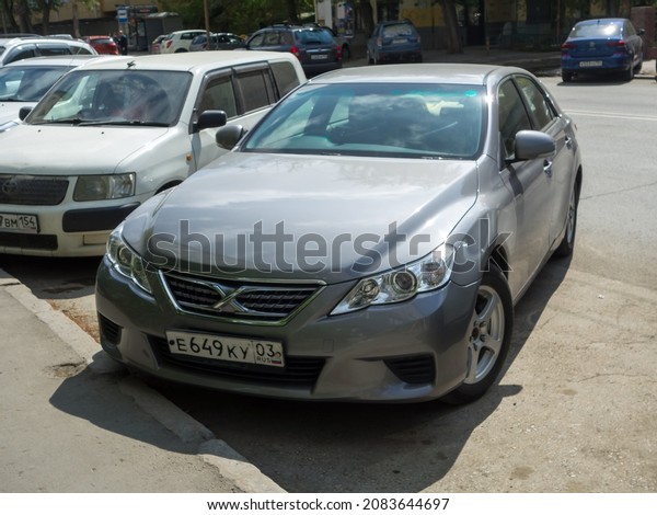 Novosibirsk, Russia, may 17 2021: private silver\
gray metallic color japanese sedan Toyota Mark X X130, rwd\
rear-wheel drive car export import made in Japan parking on morning\
sunny urban street\
area