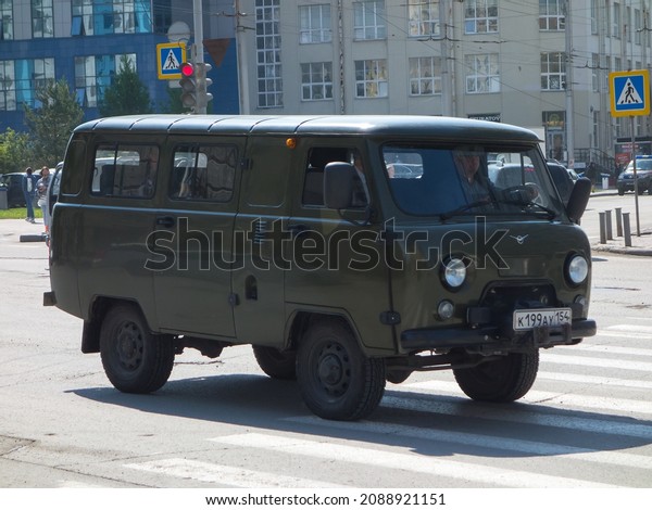 Novosibirsk, Russia, may 18 2021: private awd\
all-wheel drive khaki metallic color russian new old classic\
vintage military mini bus 4x4 4wd UAZ 3962 (452 A) car driving on\
sunny city urban\
street