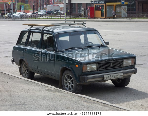 Novosibirsk, Russia - may 21 2021: dark green\
metallic color russian rwd drive old classic vintage station wagon\
VAZ Lada 2104 Zhiguli, started to be released soviet union parking\
on broad city\
street
