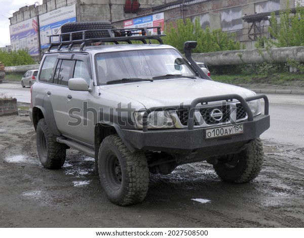 Novosibirsk, Russia - May 22 2014: private all-wheel awd
drive silver gray metallic japanese frame SUV 00s 2000s Nissan
Patrol (Safari) old car crossover exported made in Japan drive on
urban street 