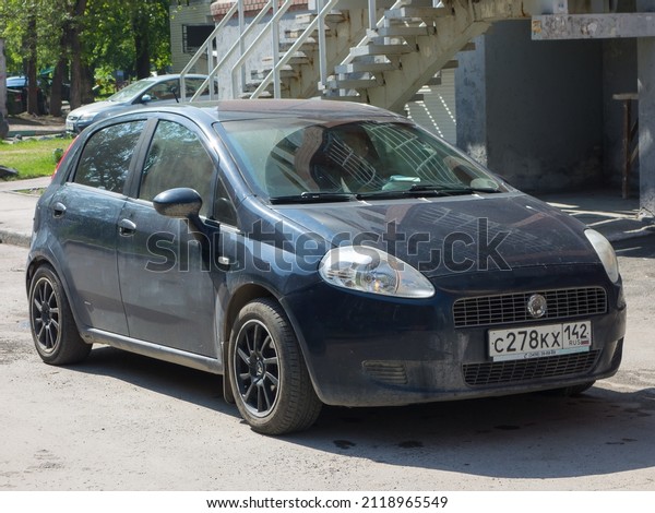Novosibirsk, Russia, may 23 2021: private\
front-wheel drive blue metallic color cheap hatch fwd FIAT Grande\
Punto III 199 budget basic hatchback car made in Italy parking on\
sunny morning road\
street