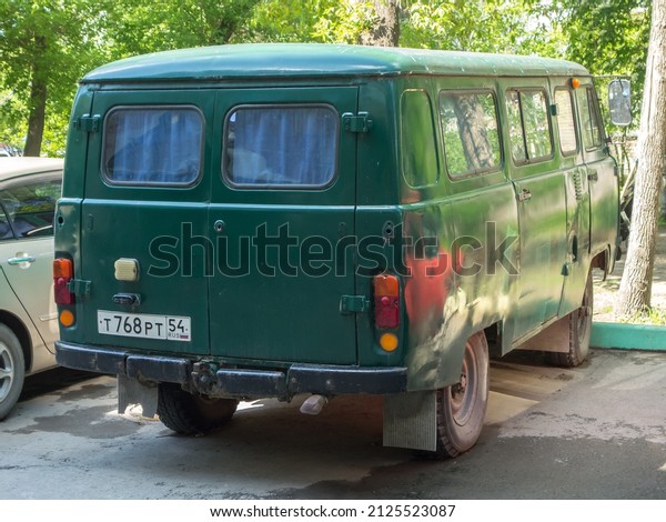 Novosibirsk, Russia, may 24 2021: private awd\
all-wheel drive green metallic color russian new old classic\
vintage military mini bus 4x4 4wd UAZ 3962 (452 B) car parking on\
city urban street\
yard