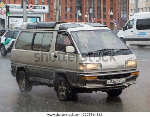Novosibirsk, Russia, may 25 2021: private silver gray\
metallic color passenger japanese compact minivan car Toyota Lite\
Ace, mini van bus export import, made in Japan drive on broad city\
urban street 