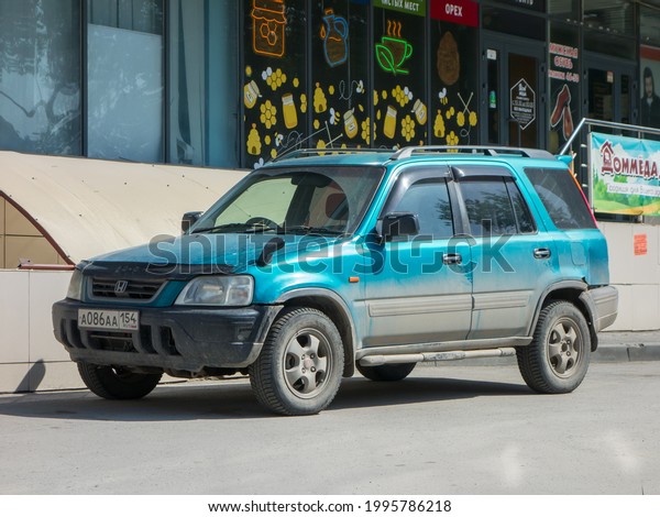 Novosibirsk, Russia - may 26 2021: private all-wheel\
drive awd 4wd 4x4 green blue metallic color japanese SUV small 90s\
2000s Honda CR-V, popular old car crossover parking city urban\
broad street 
