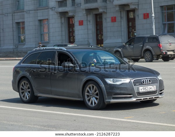 Novosibirsk, Russia, may 26 2021: private\
all-wheel drive dark gray metallic color germany new crossover 4 wd\
Audi A6 Allroad Quattro C7, midsize car made in Germany drive on\
sunny morning road\
street