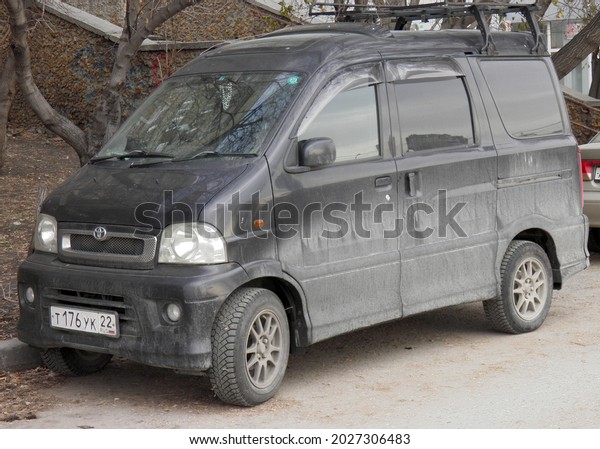 Novosibirsk, Russia - October 31 2019: private black\
metallic compact japanese passenger minivan Toyota Sparky (Daihatsu\
Hijet, Atrai 7), rare mini van bus key car made in Japan on dirty\
urban street 
