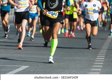 Novosibirsk, Russia - September 12, 2020: Raevich Half Marathon. A close-up of the legs of the running track and field athletes on the asphalt. Marathon runners in special sneakers