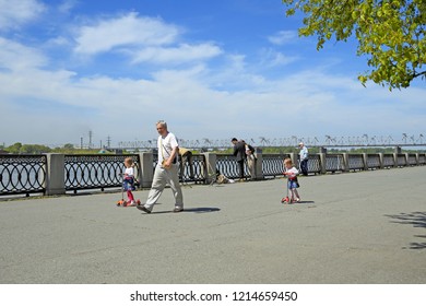 Novosibirsk, RUSSIA-JUNE 13, 2014: Grandfather walks with two twin girls along the Ob river embankment - Shutterstock ID 1214659450
