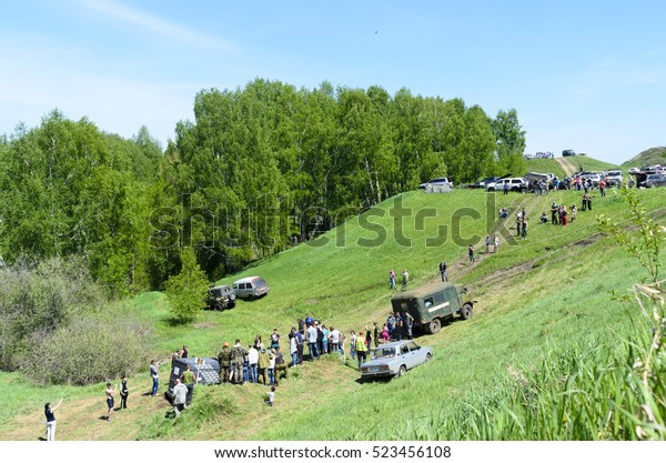 Novosibirsk, Russia-June 5, 2016:spectators watch\
the flight path of the SUV along climbing the hill in the summer in\
Novosibirsk on June 5,\
2016.