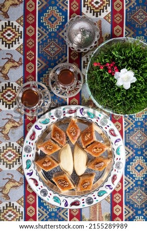 Novruz grass malt and sweets baklava and shəkərbura on a wooden tablez.A plate of Azerbaijani national dishes for Novruz - Baku-style baklava for Novruz, spring equinox and New Year festivities in Mar