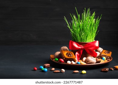 Novruz setting table decoration, wheat grass, baklava pastry and nuts on dark background. Nowruz arabic holiday, new year spring celebration, copy space. - Shutterstock ID 2267771487