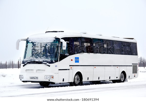 NOVYY URENGOY, RUSSIA - FEBRUARY 16, 2013: White\
SOR LH10.5 Arktika interurban coach covered by snow at the city\
street.