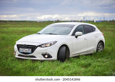 Novyy Urengoy, Russia - July 31, 2021: Compact Hatchback Mazda 3 In A Grassland.