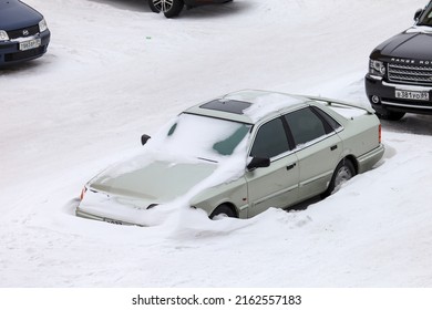 Novyy Urengoy, Russia - March 19, 2022: Abandoned Car Ford Scorpio Covered With Snow In The City Street.