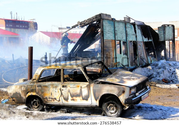 NOVYY URENGOY, RUSSIA - MAY 10,\
2015: Old car near the wooden residential house after a heavy\
fire.