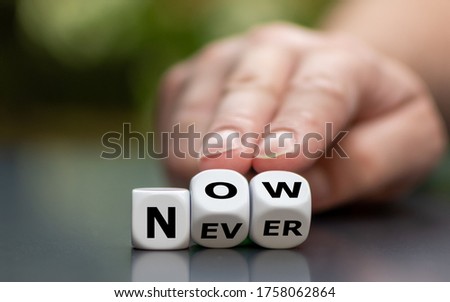 Now or never? Hand turns dice and changes the word 