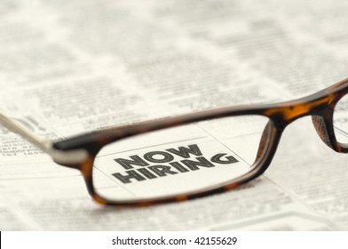 Now Hiring Classified Ad Framed In A Pair Of Reading Glasses.