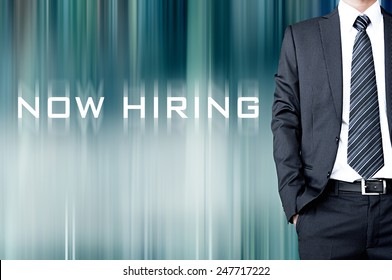 NOW HIRING Sign On Motion Blur Abstract Background With Standing Businessman