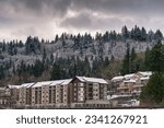 NOW MULTI COLORED APARTMETNS CONSTRUCTED SOUTH OF I-90 IN ISSAQUAH WASHINGTON WITH SNOW AND A CLOUDY SKY