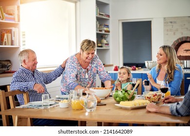 Now That The Table Is Decked, Dig In. Shot Of A Multi Generational Family Enjoying A Meal Together At Home.