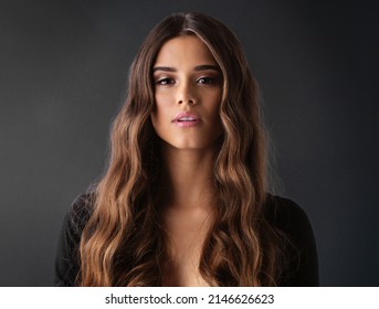 Now Thats Called A Good Hair Day. Studio Shot Of A Beautiful Young Woman Against A Dark Background.