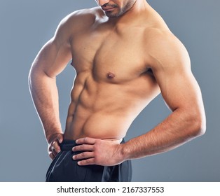 Now Thats Definitely Not An Average Body. Studio Shot Of A Muscular Young Man Posing Against A Grey Background.