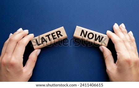 Now vs Later symbol. Concept word Now vs Later on wooden blocks. Businessman hand. Beautiful deep blue background. Business and Now vs Later concept. Copy space