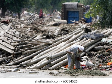 NOWSHERA, PAKISTAN - AUG 29: A man picks through debris of his house on August 29, 2010 in Nowshera. The house was destroyed by flood waters.