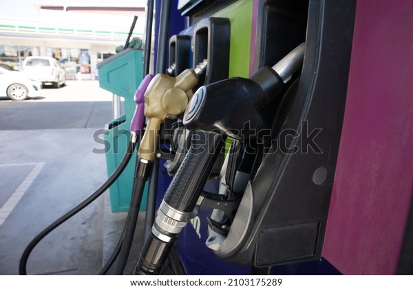 Nozzles in the\
gas station. A diesel dispenser that is filling up with a car that\
stops for fuel during the\
trip.