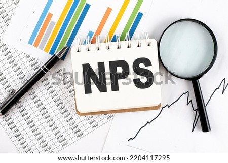 NPS text on notebook on graph background with pen and magnifier