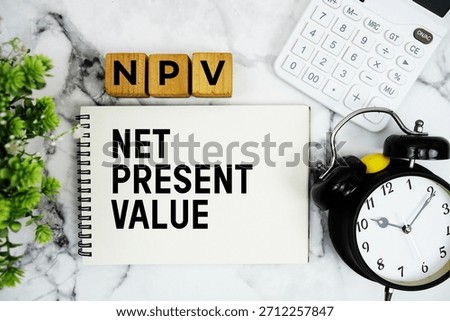 NPV Net Present Value text with calculator and alarm clock on marble background