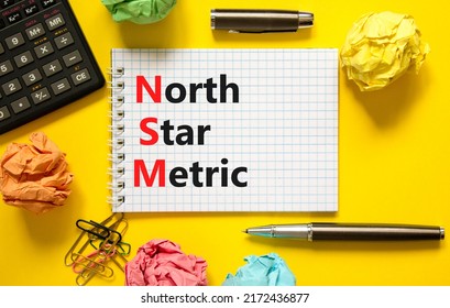 NSM North Star Metric Symbol. Concept Words NSM North Star Metric On White Note On A Beautiful Yellow Background. Calculator And Pen. Business And NSM North Star Metric Concept. Copy Space.