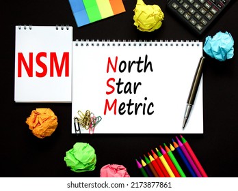 NSM North Star Metric Symbol. Concept Words NSM North Star Metric On White Note On A Beautiful Black Background. Calculator And Pen. Business And NSM North Star Metric Concept. Copy Space.